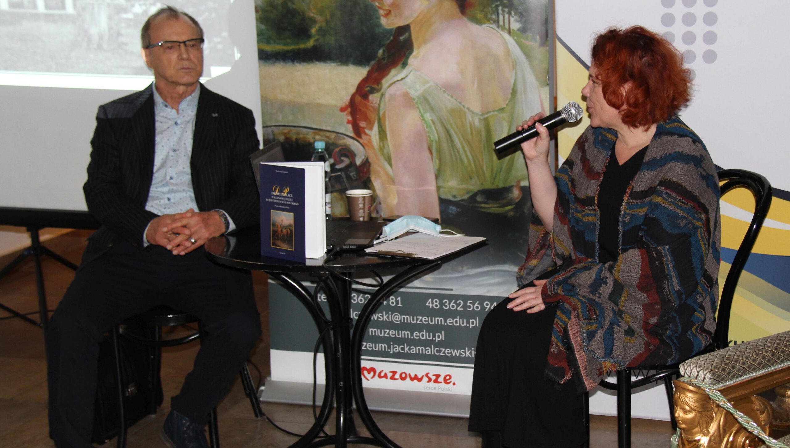 aIMG_3642 dyrektor PIK siedzi i rozmawia z autorem, promocja książki M. Kowalika "Dwory i pałace"